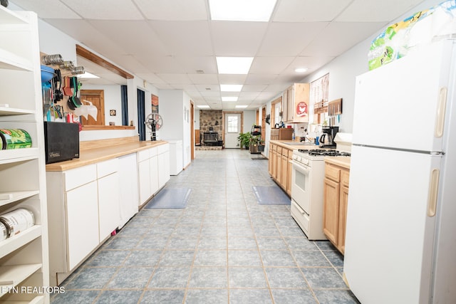 kitchen featuring tile patterned flooring, a paneled ceiling, and white appliances