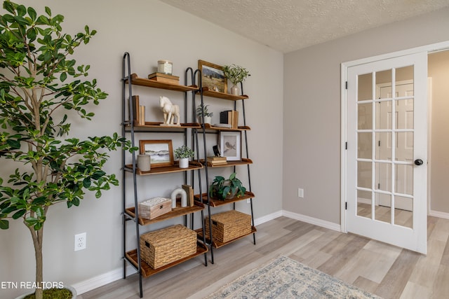 sitting room with light wood-type flooring and a textured ceiling