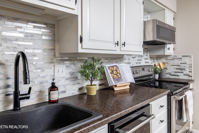 kitchen featuring sink, white cabinetry, stainless steel appliances, and tasteful backsplash