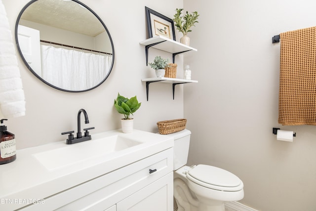 bathroom featuring vanity and toilet