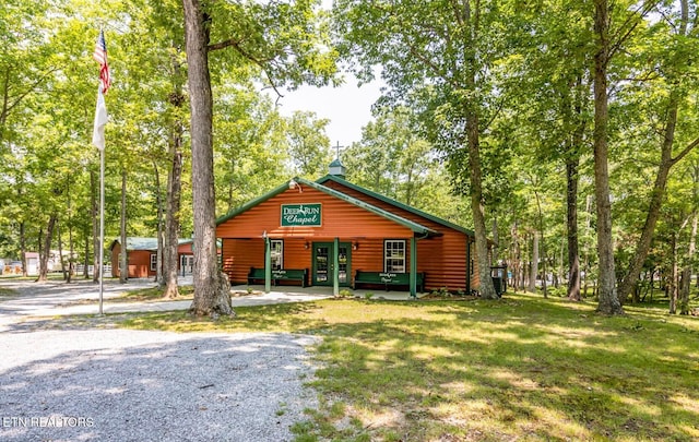 log home with a front yard and covered porch