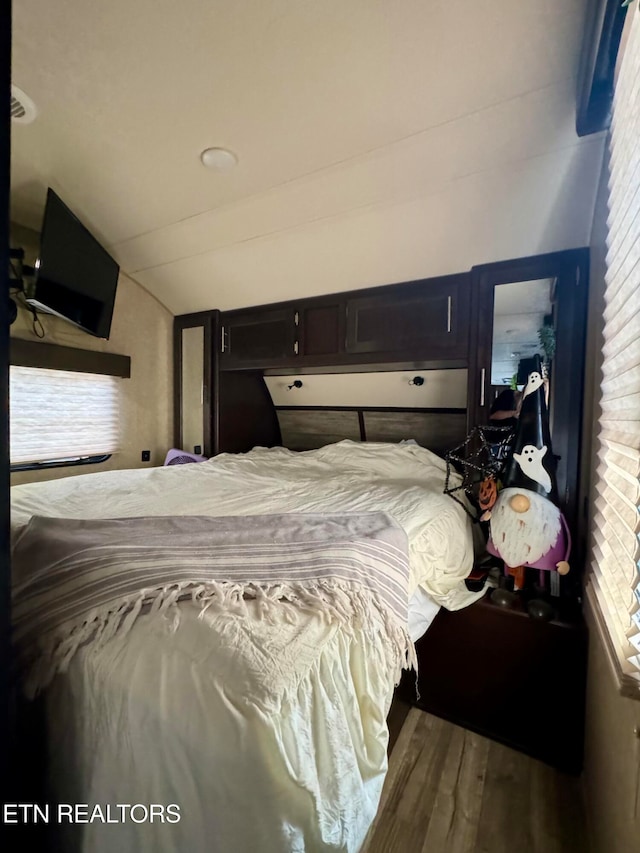 bedroom with hardwood / wood-style floors and vaulted ceiling