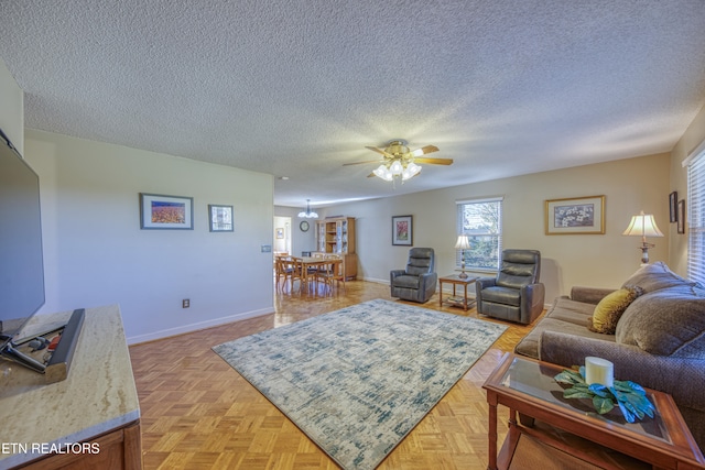 living room with a textured ceiling, light parquet floors, and ceiling fan