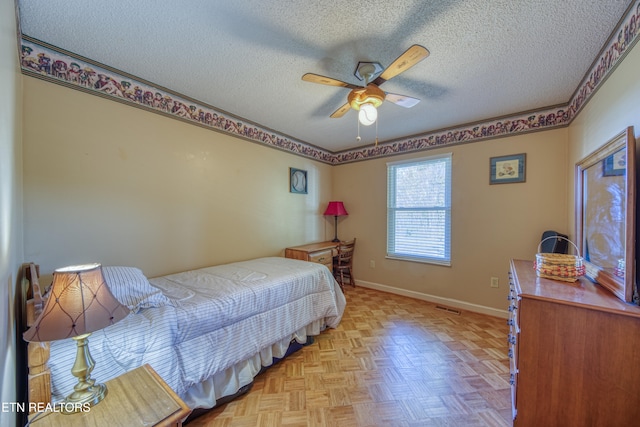 bedroom with ceiling fan, a textured ceiling, and light parquet floors