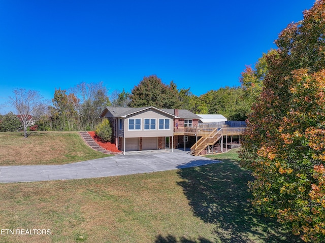 view of front of property featuring a garage, a front lawn, and a deck