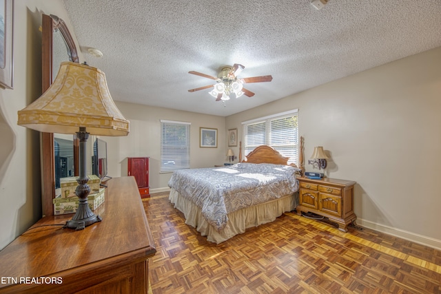 bedroom featuring ceiling fan, a textured ceiling, and parquet floors