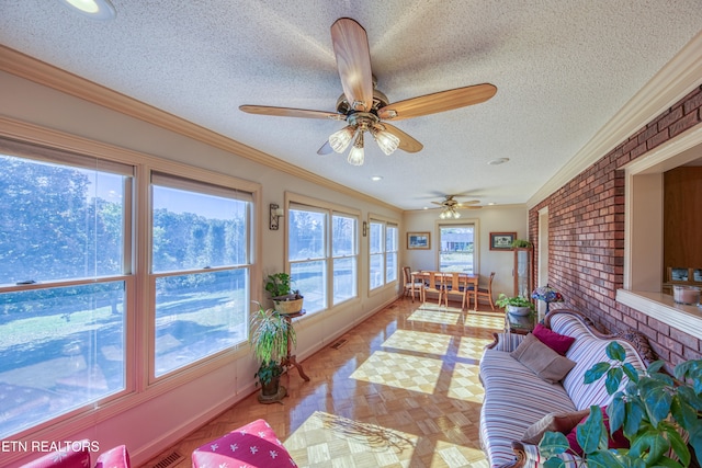 sunroom with a wealth of natural light and ceiling fan