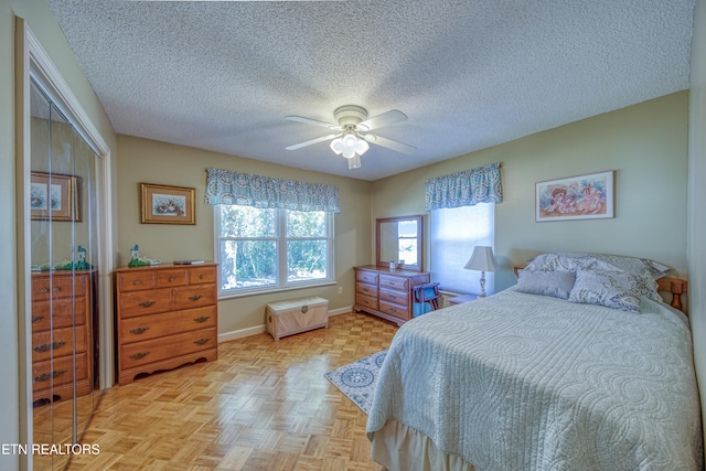 bedroom featuring a textured ceiling, multiple windows, ceiling fan, and light parquet floors