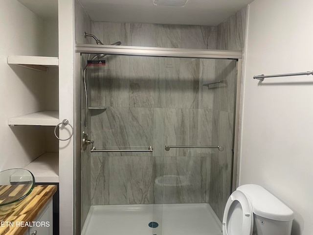 bathroom with toilet and an enclosed shower