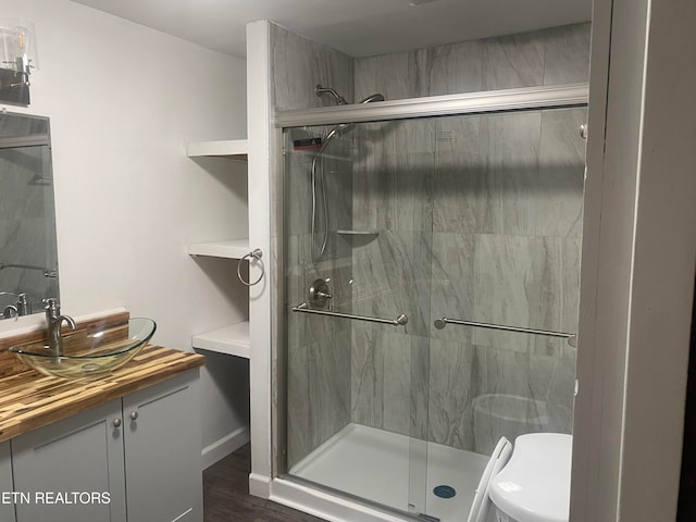 bathroom featuring walk in shower, wood-type flooring, toilet, and vanity