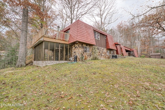 rear view of house featuring a sunroom, a yard, and cooling unit