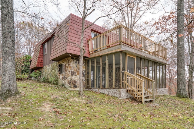 rear view of house with a sunroom and a yard