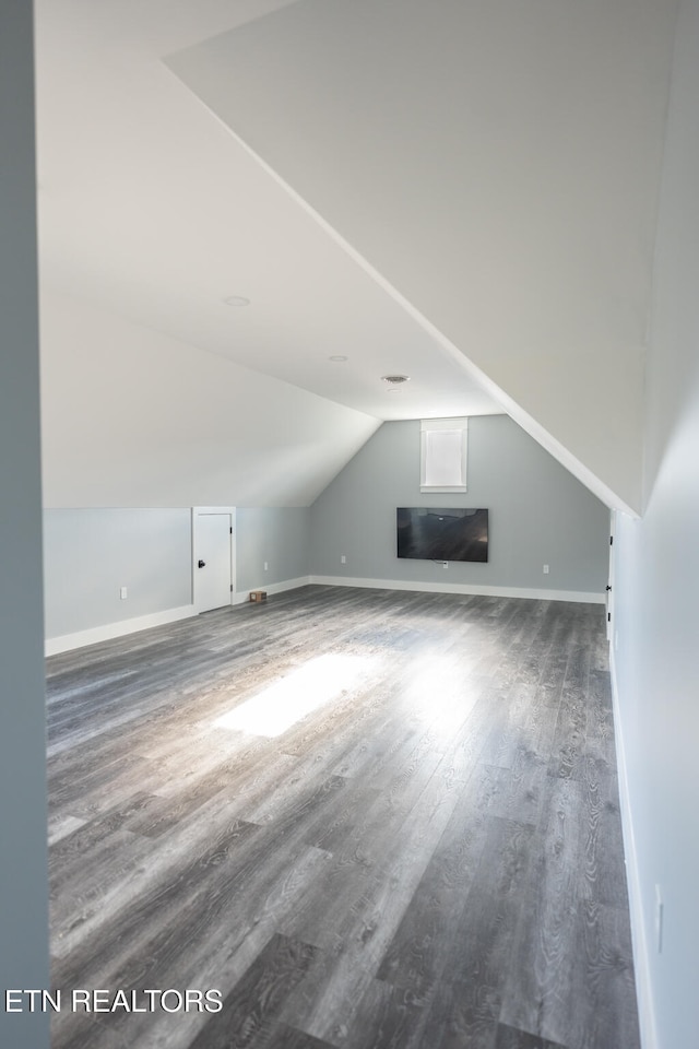 bonus room featuring dark wood-type flooring and lofted ceiling