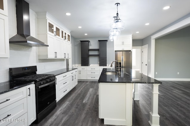 kitchen with sink, stainless steel refrigerator with ice dispenser, a kitchen island with sink, wall chimney range hood, and black range with gas stovetop