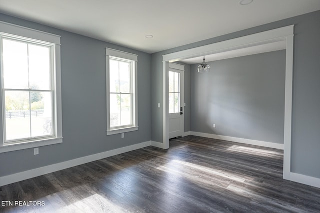 unfurnished room featuring dark hardwood / wood-style floors and a notable chandelier