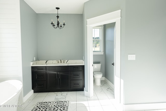 bathroom featuring a tub to relax in, vanity, toilet, and a notable chandelier