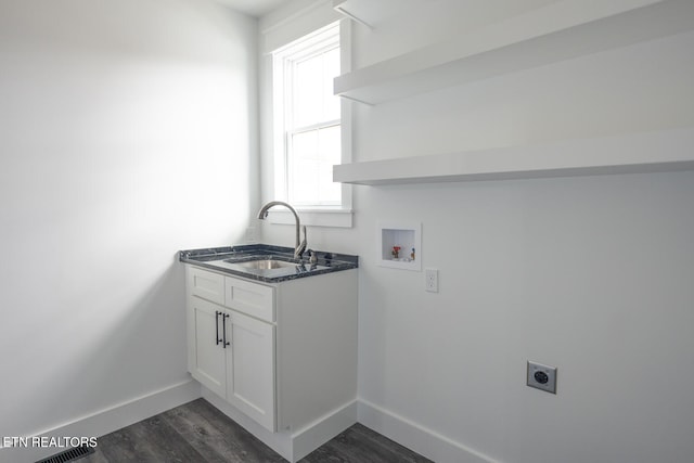 clothes washing area with dark wood-type flooring, hookup for a washing machine, sink, and hookup for an electric dryer