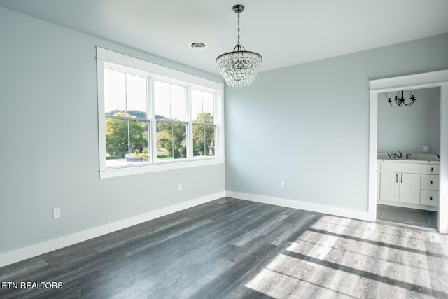 interior space featuring dark wood-type flooring, sink, and an inviting chandelier