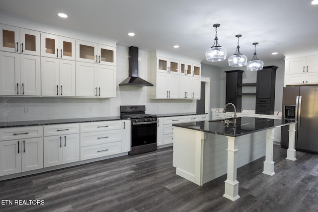 kitchen with a center island with sink, stainless steel refrigerator with ice dispenser, wall chimney exhaust hood, gas stove, and dark hardwood / wood-style floors