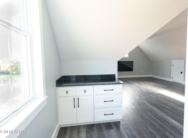 bonus room with dark hardwood / wood-style flooring and vaulted ceiling