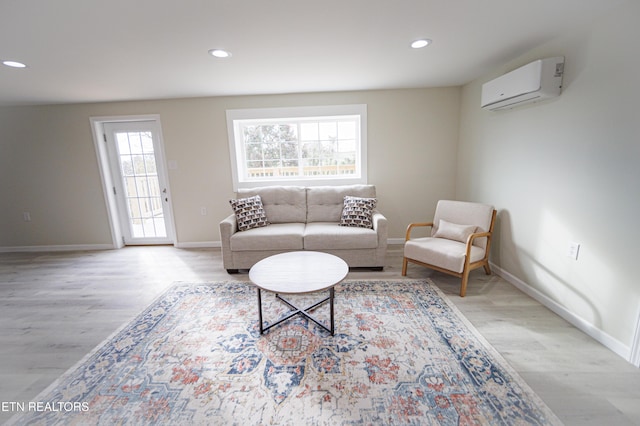 living room with light hardwood / wood-style floors and a wall mounted air conditioner