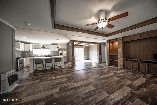 living room featuring heating unit, a textured ceiling, and dark hardwood / wood-style floors