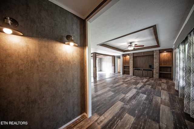 hall featuring dark wood-type flooring and a tray ceiling