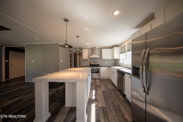 kitchen with stainless steel appliances, dark hardwood / wood-style floors, wall chimney range hood, a kitchen island, and pendant lighting