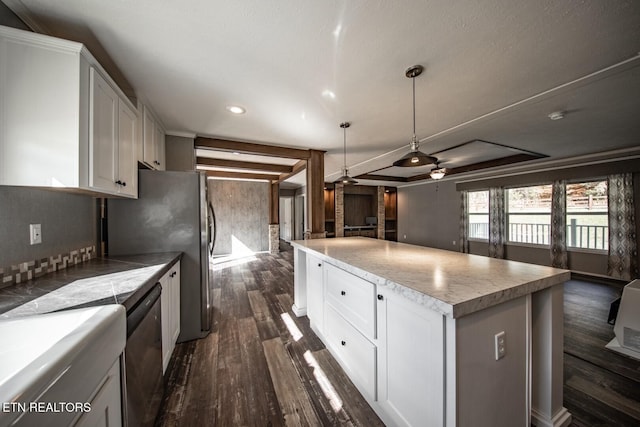 kitchen with white cabinetry, appliances with stainless steel finishes, a kitchen island, pendant lighting, and dark hardwood / wood-style flooring