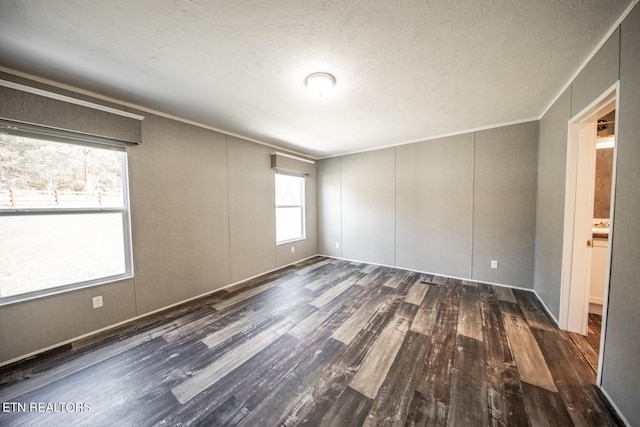 unfurnished room with dark hardwood / wood-style flooring and a textured ceiling