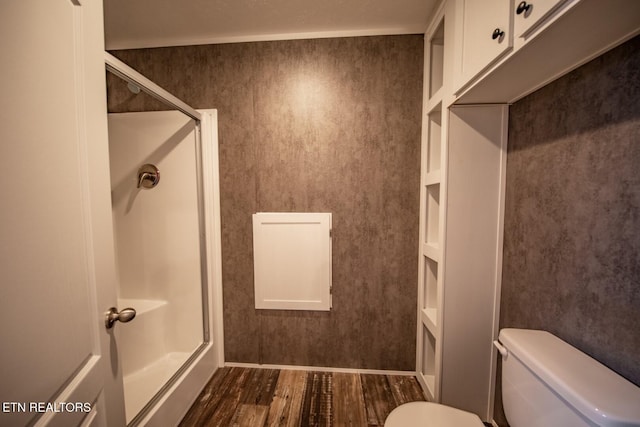 bathroom with toilet, an enclosed shower, and hardwood / wood-style flooring