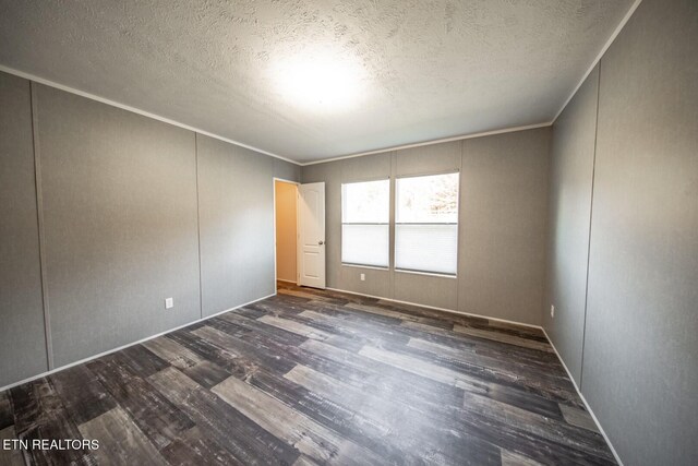 spare room with dark hardwood / wood-style flooring, a textured ceiling, and crown molding