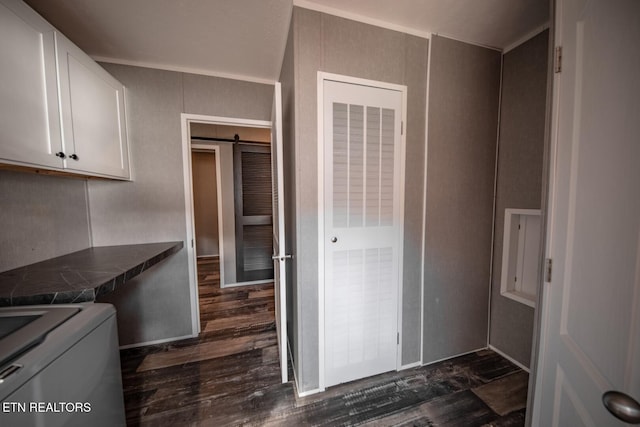 kitchen with white cabinetry, ornamental molding, washer / clothes dryer, a barn door, and dark hardwood / wood-style flooring