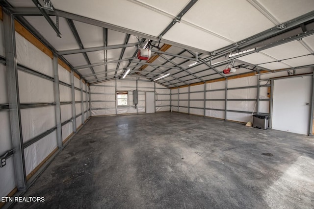 garage with a garage door opener and electric panel