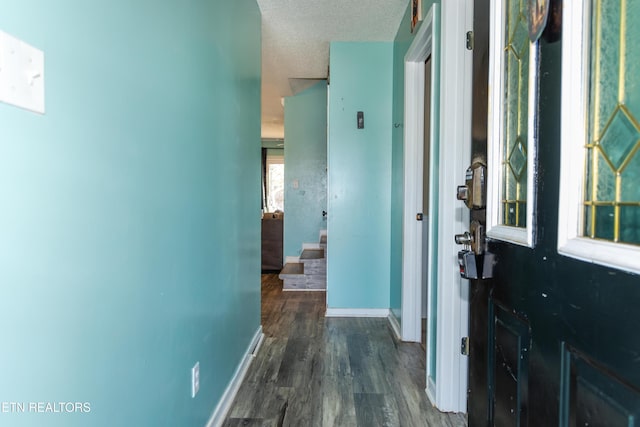 corridor featuring a textured ceiling and dark hardwood / wood-style floors