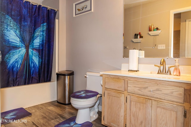 full bathroom with hardwood / wood-style floors, vanity, toilet, and shower / bath combination with curtain