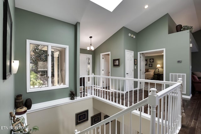 corridor featuring high vaulted ceiling, dark hardwood / wood-style floors, and a notable chandelier