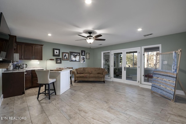 living room featuring ceiling fan and french doors