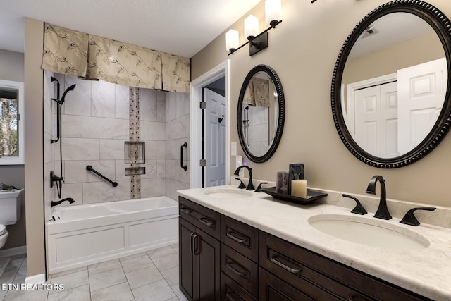 full bathroom with toilet, tiled shower / bath, tile patterned flooring, a textured ceiling, and vanity