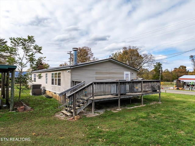 back of property with central AC unit, a yard, and a deck