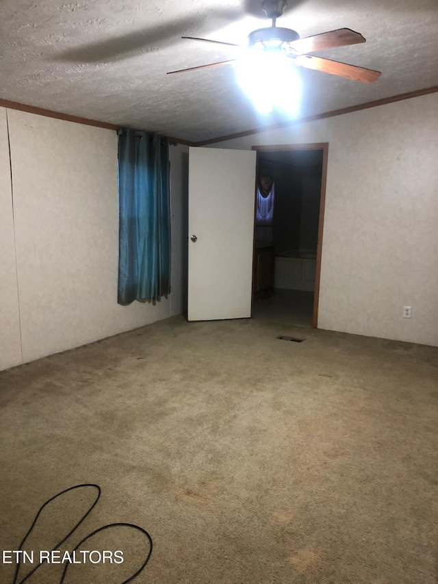 unfurnished room featuring a textured ceiling, ornamental molding, and ceiling fan