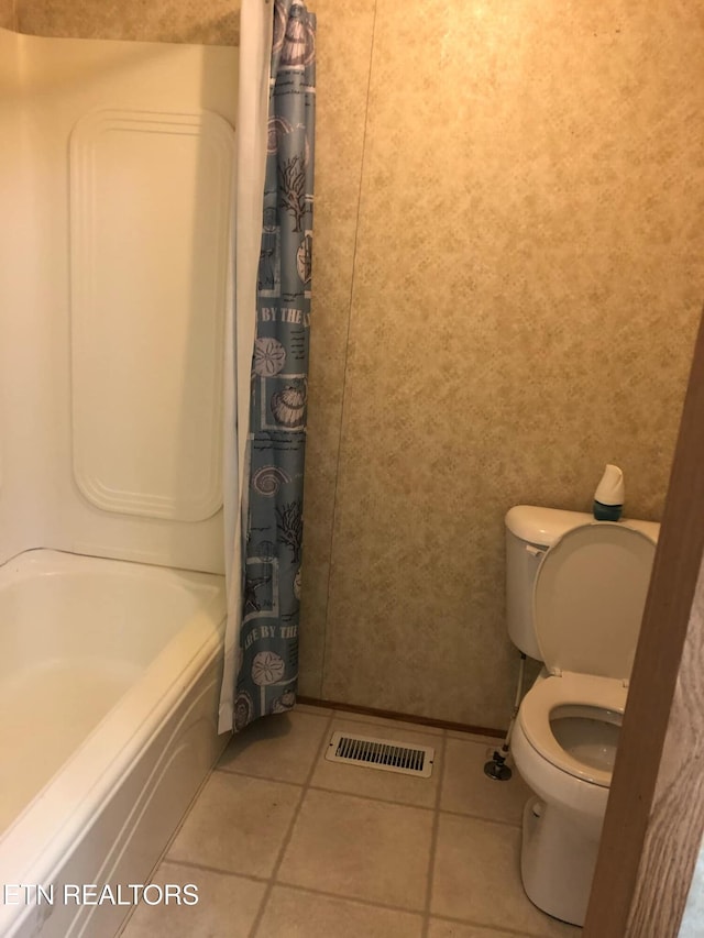 bathroom featuring toilet, shower / tub combo with curtain, and tile patterned floors