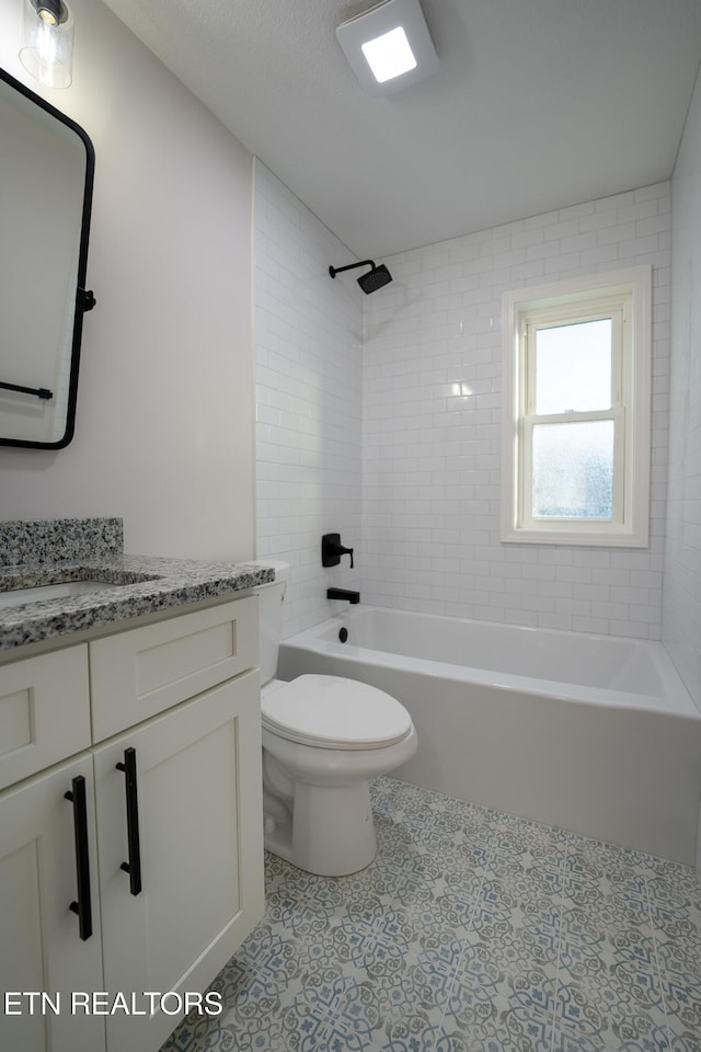 full bathroom with tiled shower / bath, vanity, and toilet