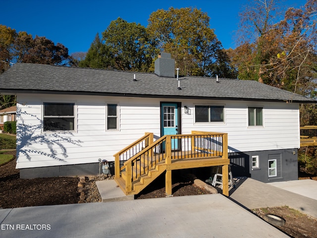 rear view of property with a deck and a patio area