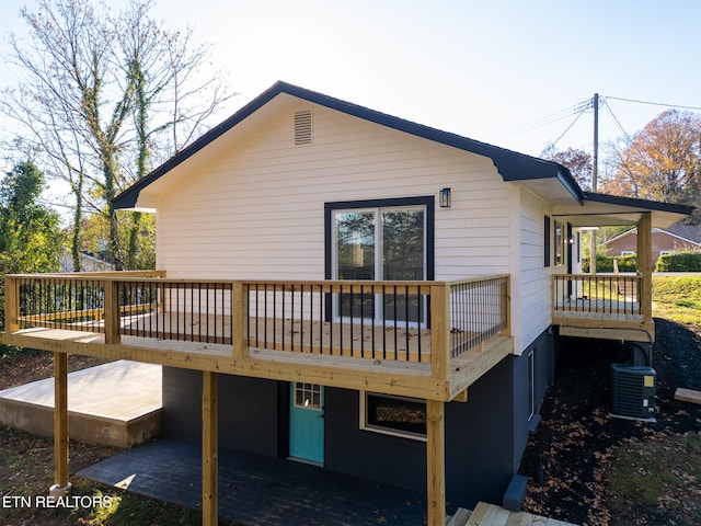 back of house with central air condition unit and a wooden deck