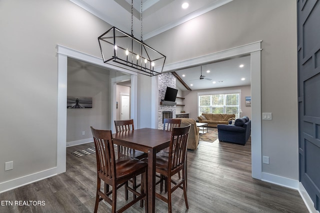 dining room with a fireplace, dark hardwood / wood-style flooring, and ceiling fan