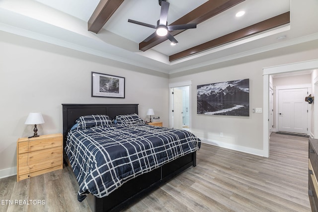 bedroom featuring ensuite bath, wood-type flooring, ceiling fan, and beam ceiling