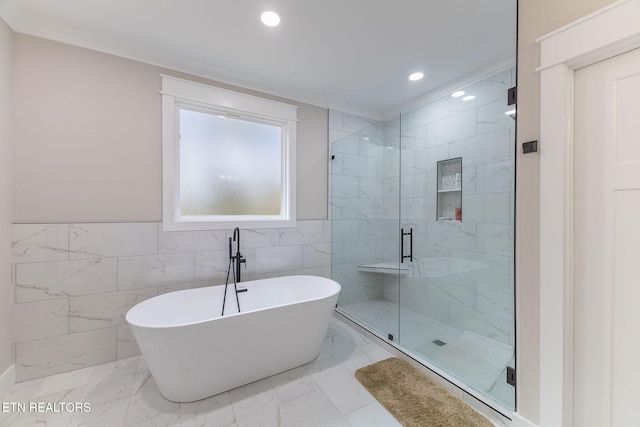 bathroom with tile walls and separate shower and tub