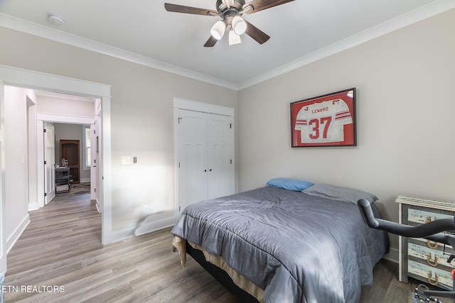 bedroom featuring ornamental molding, a closet, light hardwood / wood-style floors, and ceiling fan