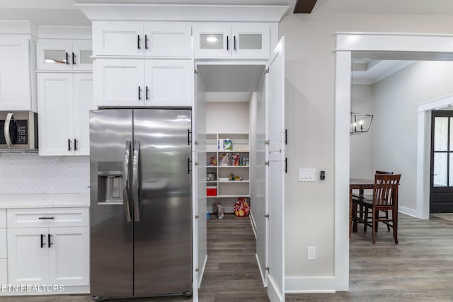 kitchen featuring white cabinets, decorative backsplash, hardwood / wood-style flooring, light stone countertops, and appliances with stainless steel finishes